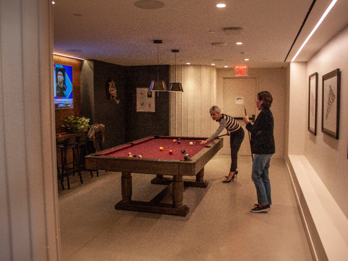 Club 75 includes a billiards room with a television for members to take a break from work.