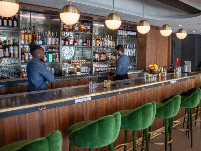 Club 75 has a full bar and restaurant, designed with green velvet bar stools and gold-toned accents.