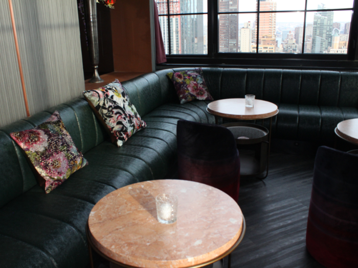 On the far side of the lounge area, couches were covered in dark green leather ...