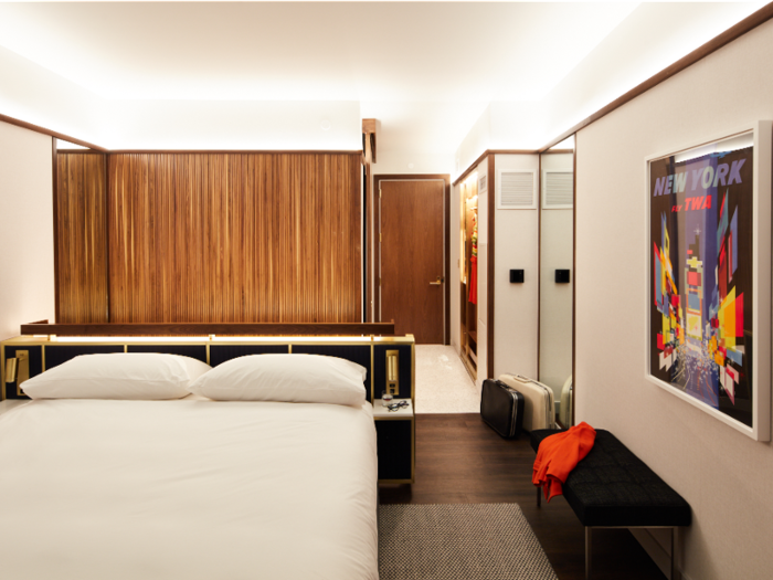 The rooms are outfitted with classic Saarinen midcentury modern furniture, walnut ceiling trim and accents, and a bed lined in brass.