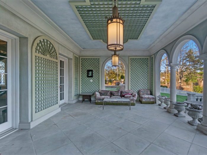 The back patio also includes an outdoor sitting area, complete with a sofa and chair.