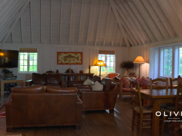 The main section of the house has a large living room with high ceilings and a wood-burning fireplace — a nice place to lounge after a long day at the lake or in the winter, after skiing on the nearby slopes.