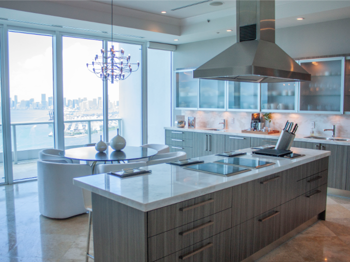 The eat-in kitchen has stainless steel appliances and marble countertops to match the floors ...