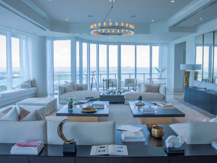 The light-filled living room is decorated in neutral tones with black and gold accents.