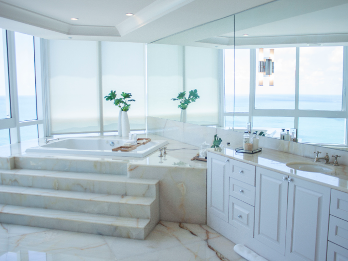 A marble soaking tub overlooks the ocean.