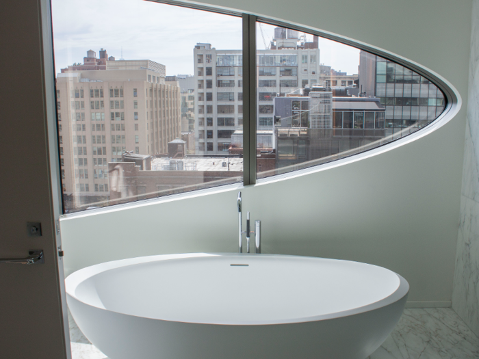 ... and a luxurious bathroom with a soaking tub and the same curved windows found upstairs.