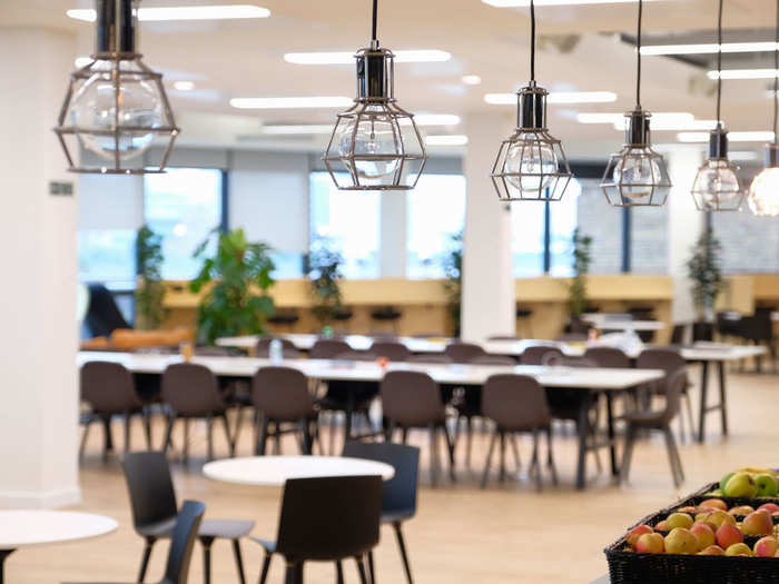 Trendy light fixtures can be found next to fruit baskets and there are multiple hot-desking zones throughout.