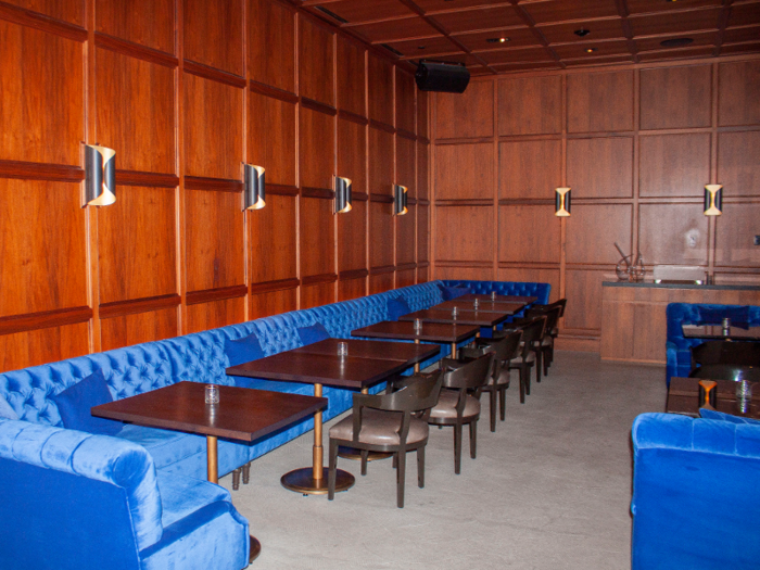 The wood-paneled dining room features electric blue velvet banquettes.