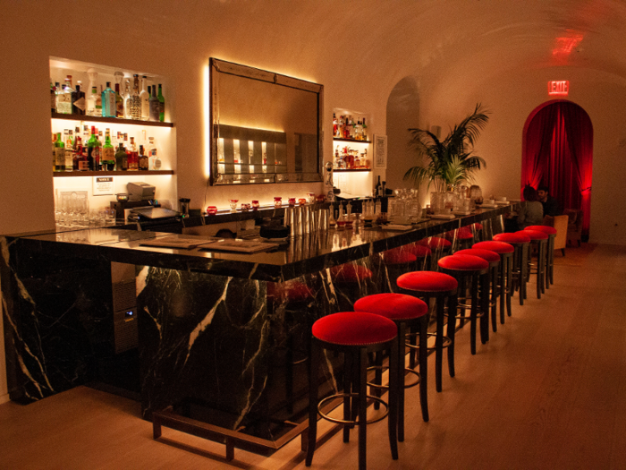 Red velvet stools were lined up at the black marble bar.