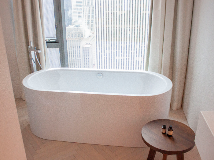 The bathroom includes a walk-in shower and a deep soaking tub overlooking the city.