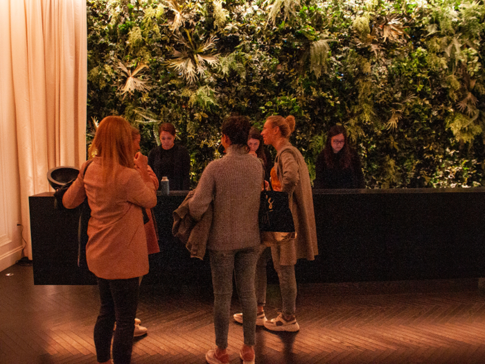 The lobby is on the 10th floor, where a sleek black check-in desk sits in front of a floor-to-ceiling plant wall.