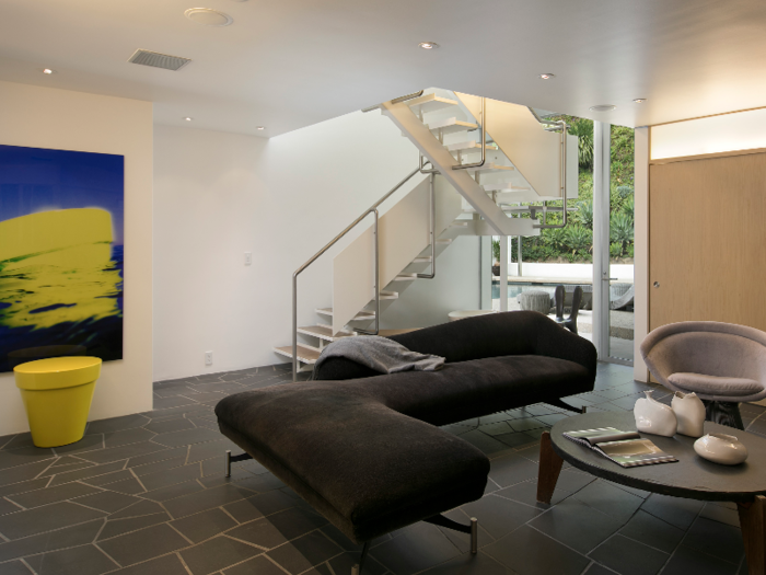 A steel floating staircase connects two levels of the home.