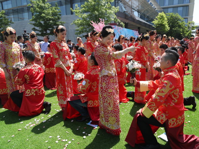 The grooms present the brides with flowers.