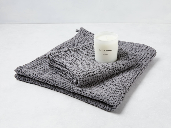 A fancy towel and candle set to make a hotel room feel like home