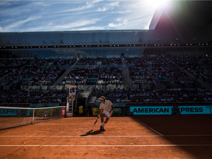 Federer runs to the net under blue skies at the Madrid Open.