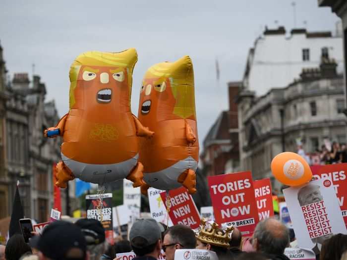 Smaller, but similar, balloons also hung in the air above the crowd alongside signs demanding the ouster of Tory politicians (British lawmakers in the conservative party).