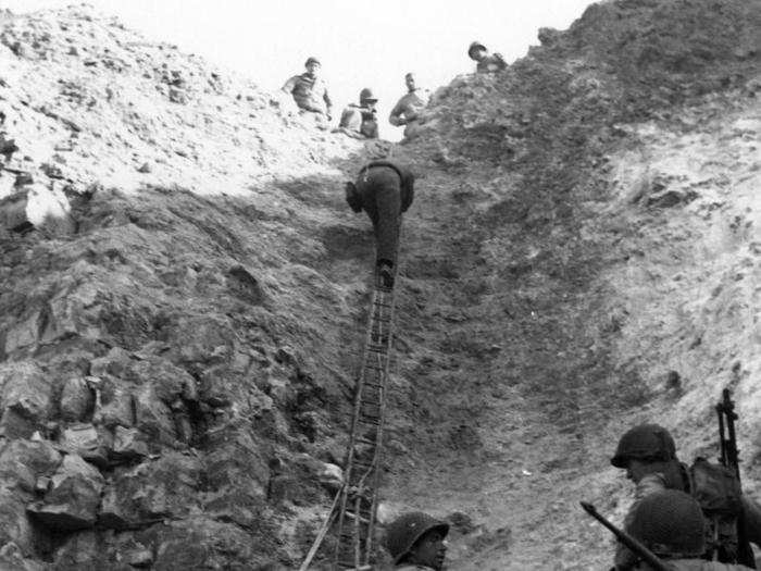 The Rangers climbed up wet ropes and ladders in damp, muddy uniforms as German bullets and grenades rained down on their assault.