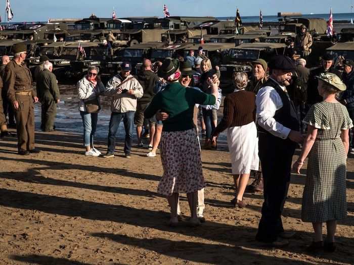 Over on Asnelles Beach in Normandy, visitors dressed up in period fashion danced on the beach next to old military vehicles on display.