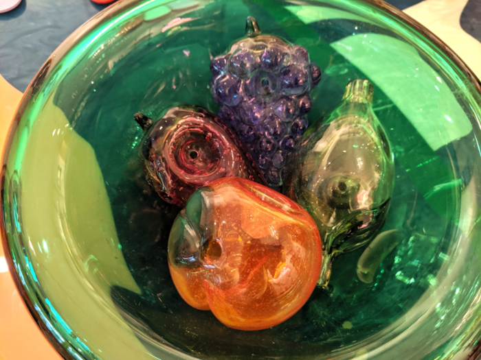 The Flower line includes hand-blown glass pipes in the shape of various fruits, from strawberries to bananas to a bunch of grapes.