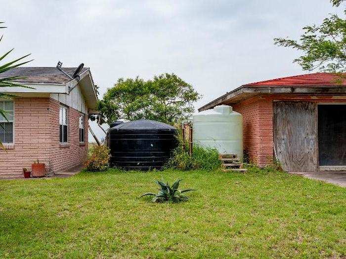 Potable water is stored in large cisterns, like these two between homes on Weems Road.