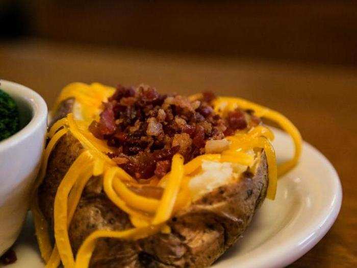 The baked potato was topped with cheddar and bacon bits. Underneath was a bed of butter and sour cream.