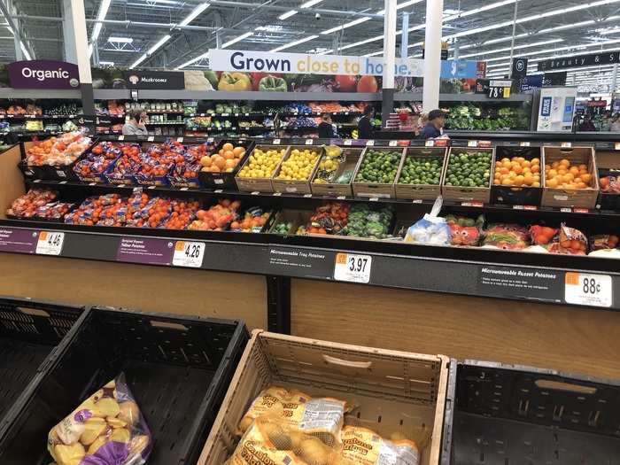 ... and fresh produce in the center of the floor and also lining a wall behind.