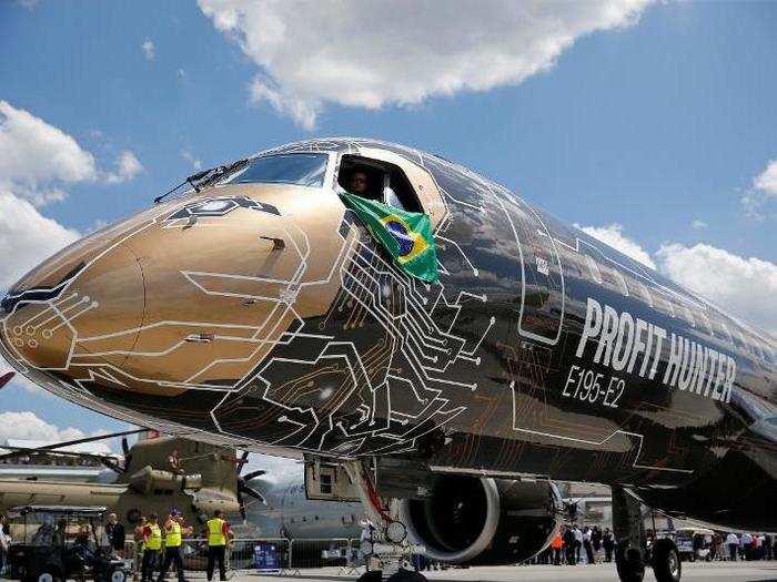 The Brazilian flag peeks out of the cockpit of of an Embraer E195-E2. The plane