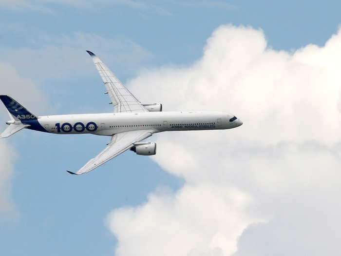 The Airbus A350 1000, a passenger jet, soars through the clouds.