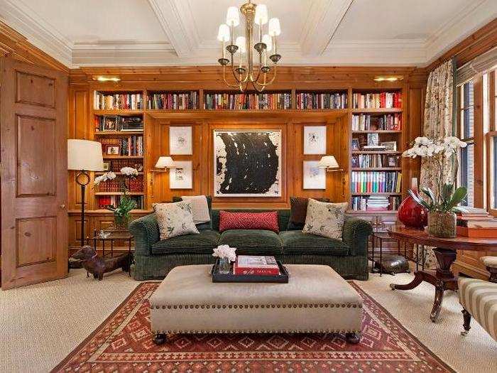 The study includes a wood-paneled library, while the living room includes a wood-burning fireplace.