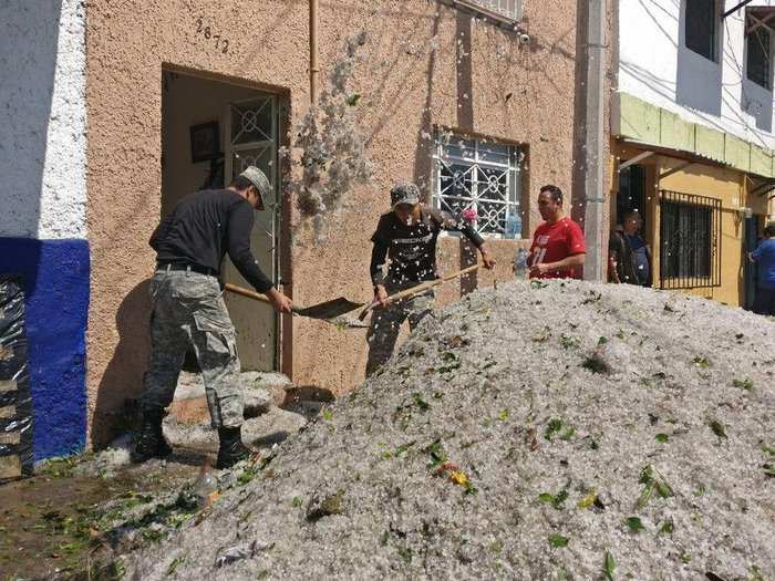 The onslaught of ice damaged nearly 200 homes and businesses, AFP reported. Here, officials help shovel ice from a building entrance.