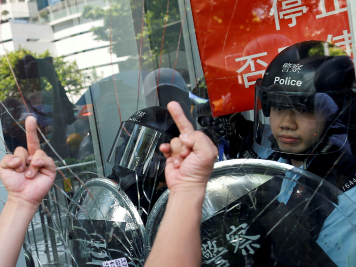 After unsuccessfully accessing the site of the flag-raising ceremony, protesters tried to enter the headquarters of the Legislative Council. Hundreds surrounded the building, smashing windows and tearing down parts of the glass and metal exterior.