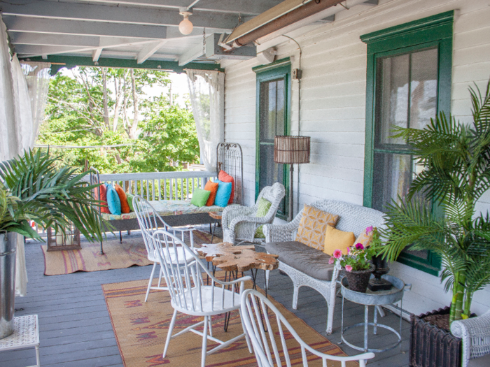 An elevated plant-filled porch wraps around the front face of the hotel, overlooking the terrace.