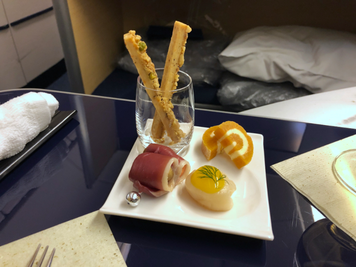 It started with a slightly different amuse-bouche plate: a pistachio-coated nut stick, duck prosciutto wrapped around a marinated mushroom, an apricot and butter roll, and a smoked scallop with mandarin orange sauce.