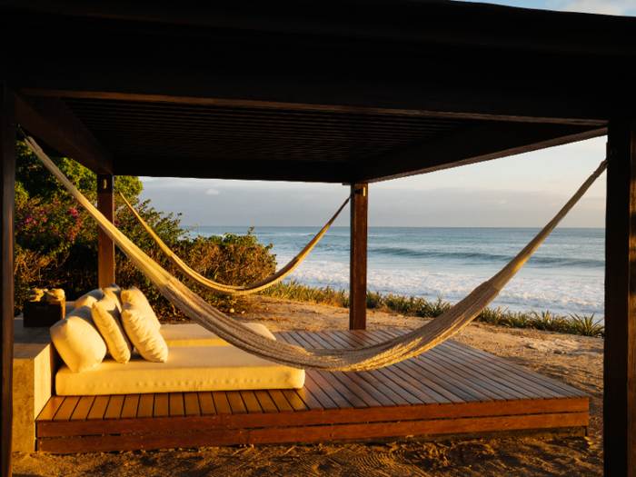 A cabana with hammocks and day beds sits on the private beach.