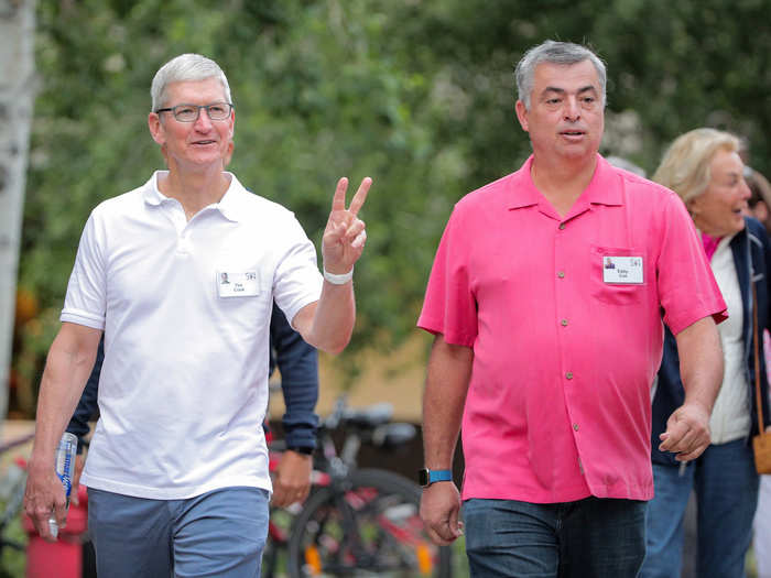 Apple CEO Tim Cook (left) walks with Apple Senior VP of Internet Software and Services Eddy Cue (right).