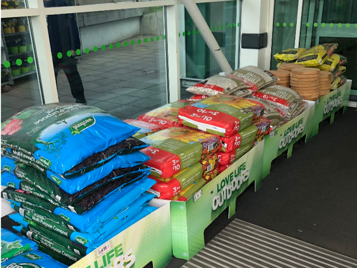 The entrance of Asda was full of gardening materials, like mulch ...