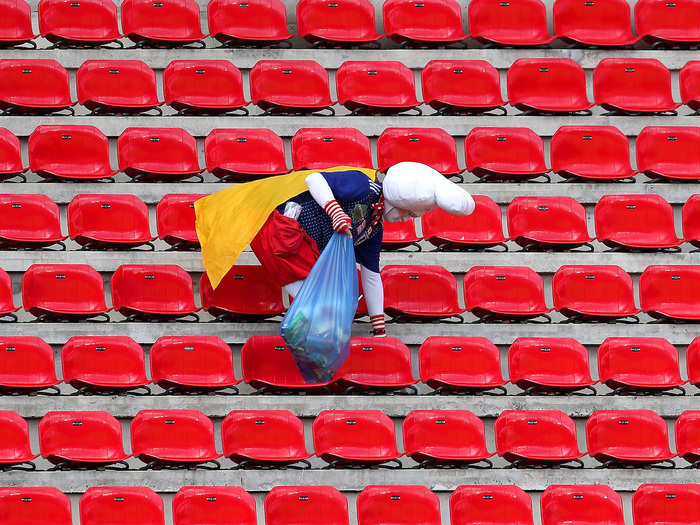 Between capturing fan moments, like this Team Japan fan picking up litter among a sea of red bleacher seats after a match between Japan and Scotland ...