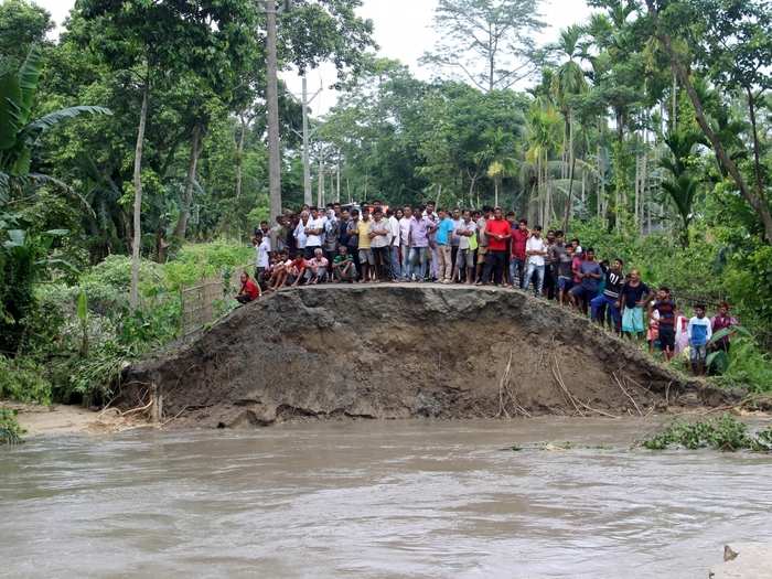 People take refuge from flood water on a highland at Hajo in Assam