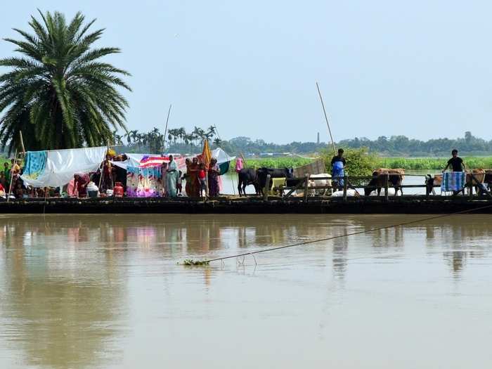 A wooden bridge over Mora Kalahi river comes to the aid of flood victims in Boko in Assam.