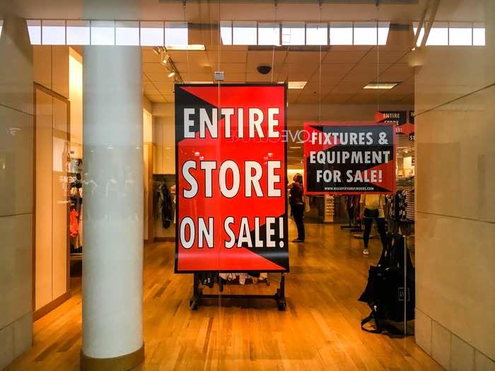 Its windows and walls were littered with red sale signs.