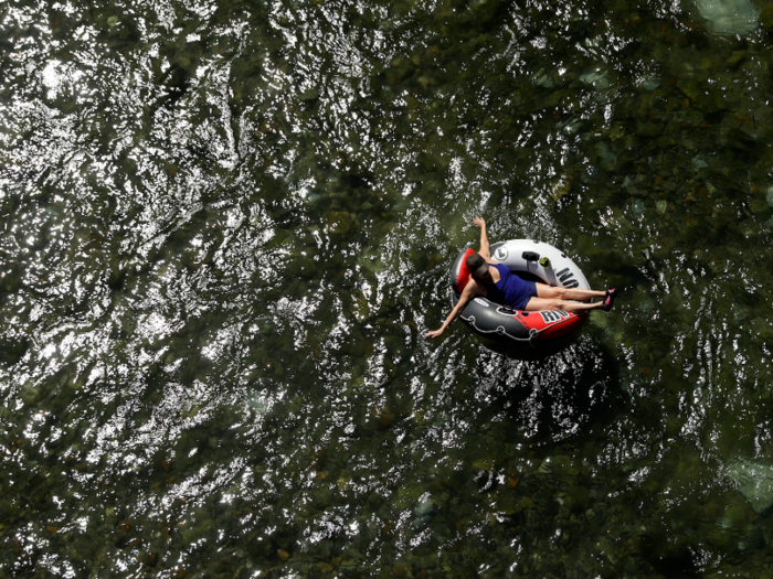 And here, lying back, another person enjoys a slightly less rough ride along the Comal River in Texas.