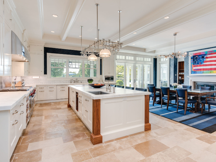 ... and includes a library, a 10-seat theater, and 2,000 square feet of covered porches. According to the listing, the kitchen is replete with a walk-in refrigerator and a wine room.