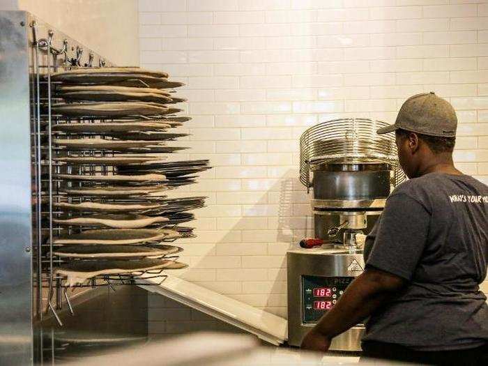 The dough is prepared by a MOD team member and stored in racks ready for immediate use.