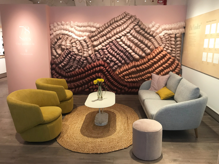 The store includes a lounge area near the front where shoppers can wait to chat with a fit stylist from beneath a wall made entirely of bras.