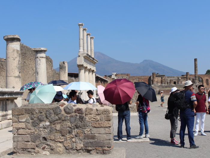 Some prudent tourists had the foresight to bring umbrellas along with them ...