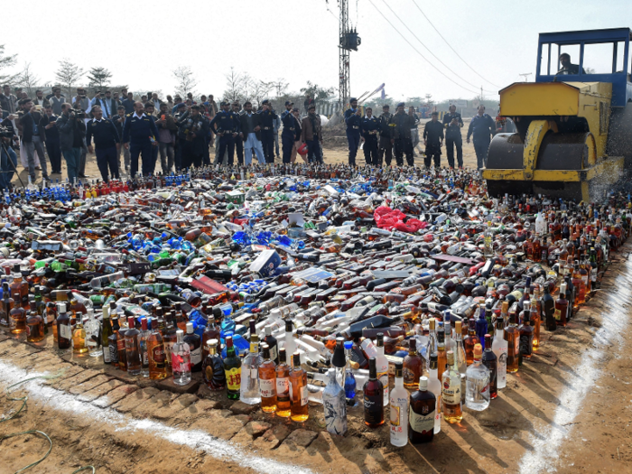 Pakistan banned alcohol for Muslims in 1979. Here, Pakistani customs officials crush contraband bottles of alcohol at the border in January 2019.