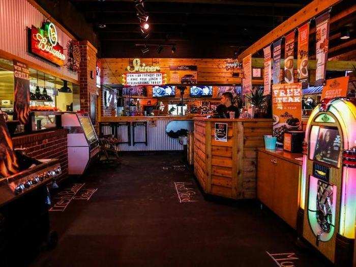 The decorators had gone ham with the roadhouse decor: neon signs, an iridescent jukebox, and wood plank everything.