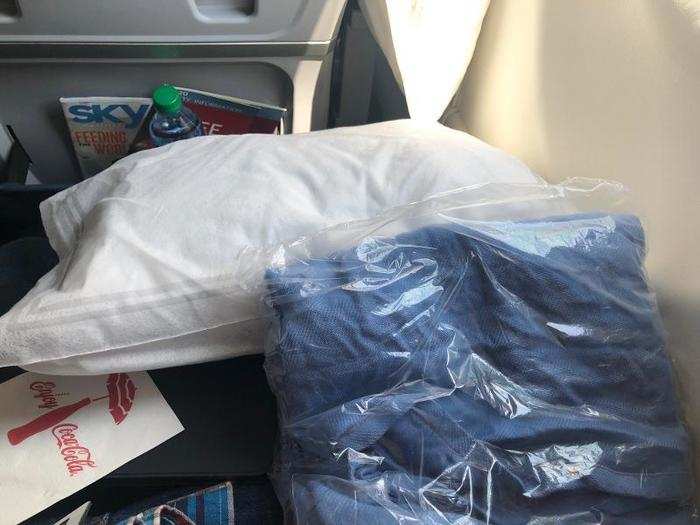 First-class passengers got a small pillow and a plastic-wrapped blanket. Always appreciated, though I ended up just tucking them out of the way between my seat and the bulkhead.