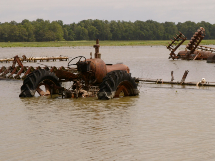 The floodwaters swallowed up tractors on farmland near the Mississippi River.