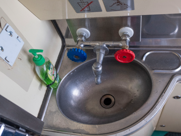 The sink was tiny, maybe slightly larger than an airplane sink. The first time I used it, I squirted soap all over my hands and then tried to turn the red knob. Nothing happened. Assuming it was broken, I rubbed the soap off my hands with a paper towel and went back to the compartment.